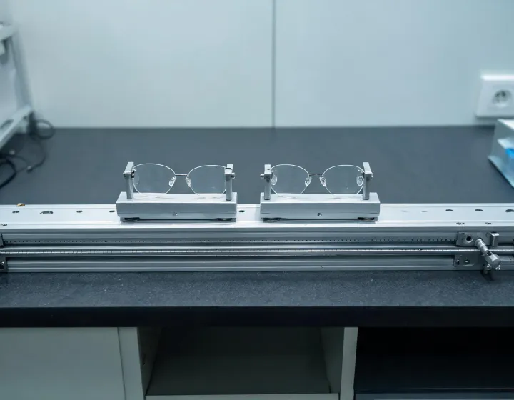 Unlabeled custom prescription lenses staged on an optical bench
